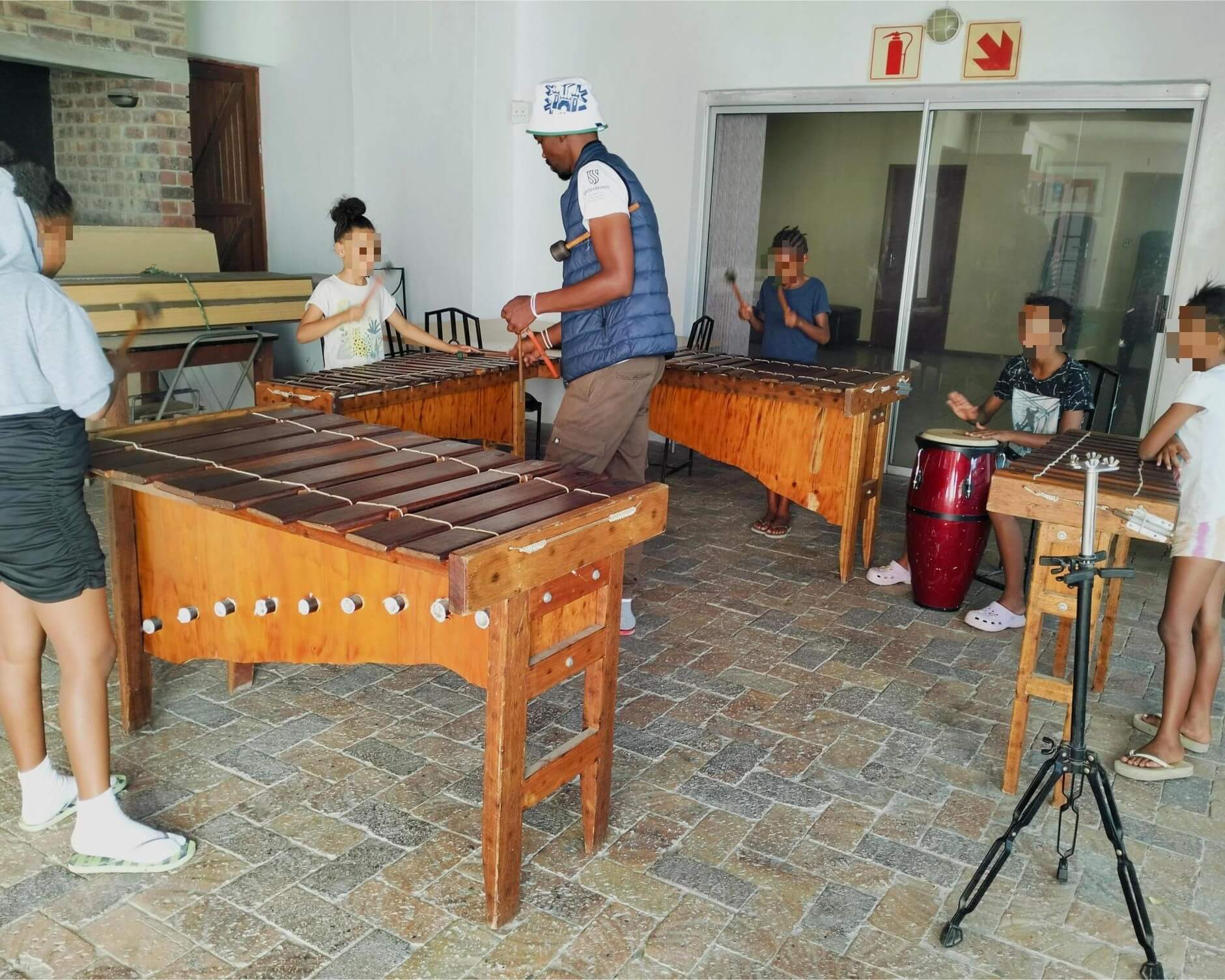 Children being instructed by their marimba teacher